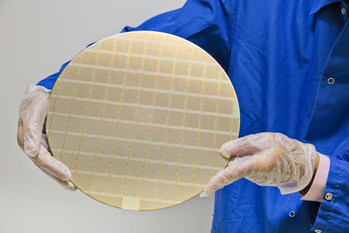 A collection of IBM POWER10 7nm processors on a silicon wafer. The wafer is cut into individual chips that become the “brains” behind IBM Power Systems servers. Each IBM POWER10 chip can deliver up to 3x the capacity and energy efficiency of the previous generation and up to 20x faster INT8 AI inferencing. Credit: Connie Zhou for IBM
