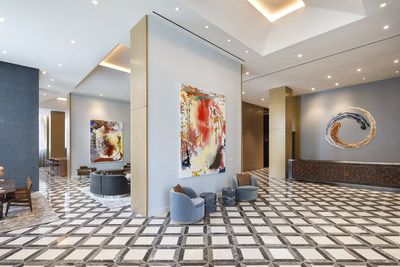 The lobby at The Joseph, a Luxury Collection Hotel, Nashville, features a custom-designed reception desk with leather paneling by Lucchese, and ceramic art by artist Brie Ruais (behind desk) and paintings by artist Jackie Saccoccio.