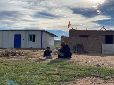 Deux habitants du lieu assis devant une tente noire tibétaine, une habitation traditionnelle des nomades locaux /CGTN (PRNewsfoto/CGTN)