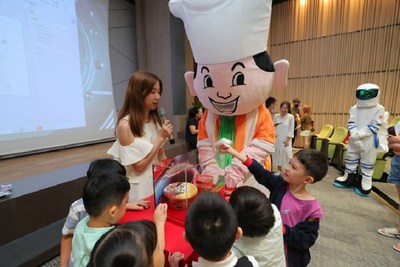 Photo shows staff explaining Master Kong's space Instant noodles to the younger generation.