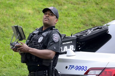 Police officer using the drone controls for surveillance detail.