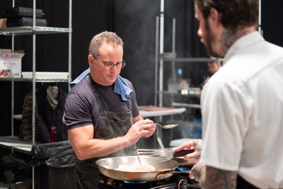 Chef Paul Kahan preparing a meal for guest at the Pilot Light Feed Your Mind Gala