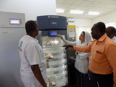 Helping Hand for Relief and Development staff examining new blood storage refrigerator in Zanzibar.