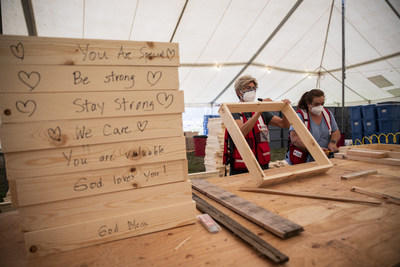 A volunteer working in partnership with the American Red Cross writes words of support on sifters. These sifters will be used to salvage items remaining at burned homes in the Silverton, Oregon area. (Photo by Scott Dalton/American Red Cross)