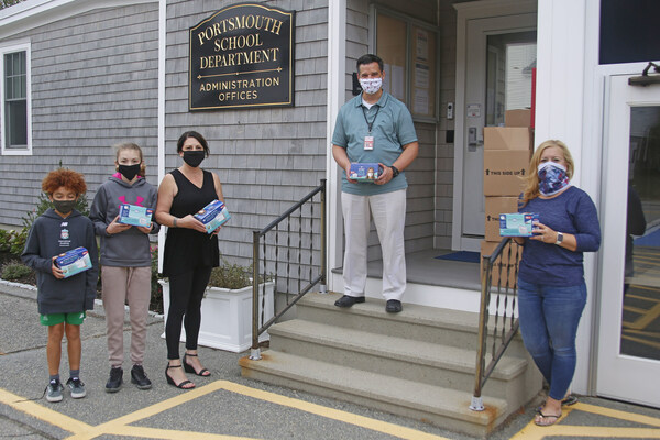 Dr. Thomas Kenworthy, superintendent of Portsmouth, RI schools, (center) accepts mask donations from Embrace Home Loans Director of Communications Jennifer O'Neill (left) and Loan Officer Dawn Ryan (right). Also pictured are students Eoin Soler and Norah Mateos.