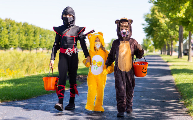 Three children dressed up in costumes with matching masks