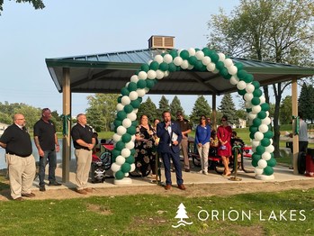 Township Supervisor Chris Barnett addresses the residents, local officials, and residents at the Orion Lakes ribbon-cutting ceremony.