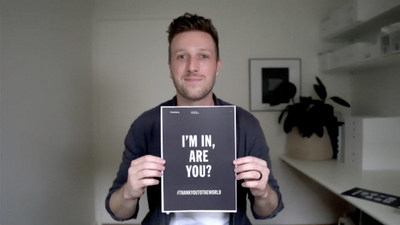 Image of Thankyou co-founder Daniel Flynn holding "I'm in, are you?" campaign sign written in English.