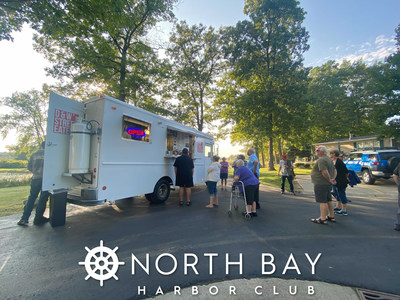Residents and other attendees, at the North Bay Harbor Club ribbon cutting ceremony, enjoy complementary food by local establishments.