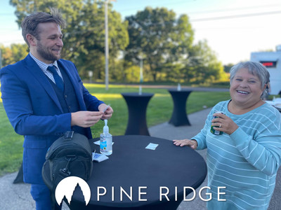 A Pine Ridge resident enjoys a laugh with local magician, Evan Priem, at the Pine Ridge ribbon cutting ceremony.