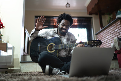 Acoustic guitar teaching through a video call, waving to laptop