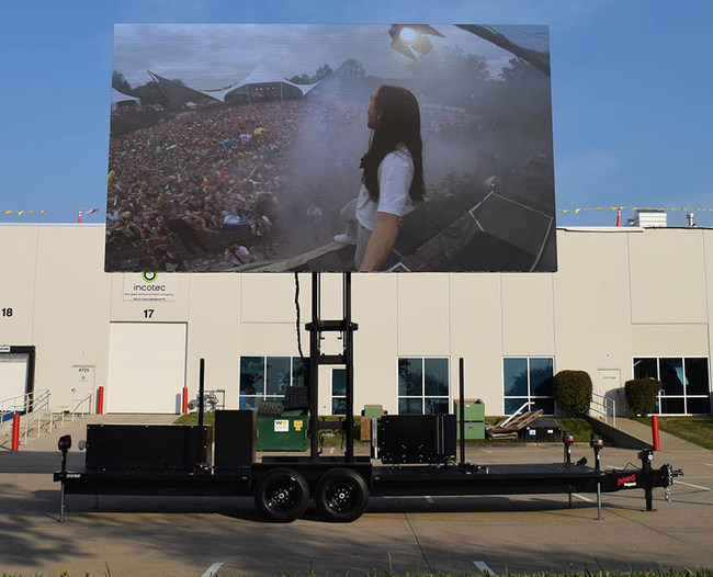 Insane Impact's new 23'x13' LED screen trailer product named MAX 2313 displaying a demo video in the parking lot.