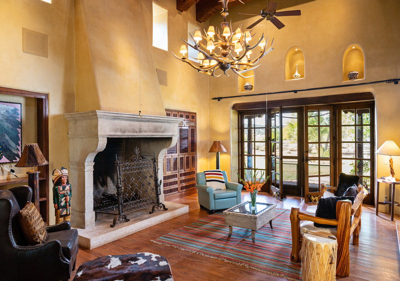 The living room in the “Drogheda House” – one of the two luxury residences on the ranch – is shown here. The home’s design is influenced by the area’s traditional, adobe style. Discover more at NewMexicoLuxuryAuction.com.