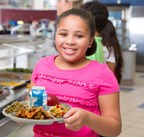 Picture of a student holding up a lunch tray with healthy food 