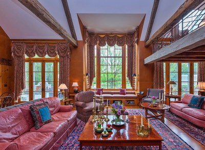 The residence’s grand salon features a soaring cathedral ceiling, with hand-hewn beams reclaimed from NYC’s famed Fraunces Tavern and one of the Adirondack “great camps” of upstate New York. The salon includes a wood-burning fireplace, wet bar, and a decorative wall covered in American Bison leather (not pictured). Large windows allow for ample, natural light. NewJerseyLuxuryAuction.com.