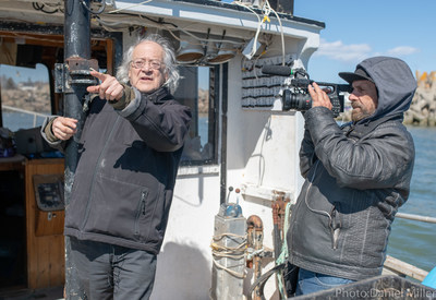 Raôul Duguay et Yves Langlois. Tournage en mer sur les traces de son grand-père. Crédit de la photo: Daniel Miller. (Groupe CNW/Publiciterre)