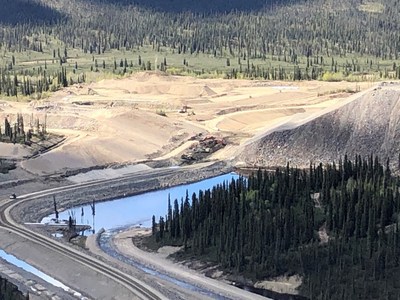 Une drivation temporaire de l'eau se dverse dans un rservoir ( droite) alors que la construction du nouveau canal tait en cours  travers l'ancienne route de transport de la mine ( gauche). (Groupe CNW/Relations Couronne-Autochtones et Affaires du Nord Canada)