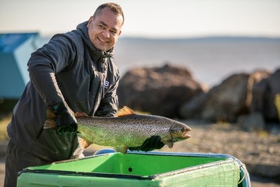 Dr Kurt Samways chargeant un poisson dans un réservoir pour être transporté à la rivière par hélicoptère. 
Mérite: Nigel Fearon Photography (Groupe CNW/Parcs Canada)