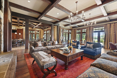 The kitchen opens to the main salon, where more beautiful woodwork is on display. Floor-to-ceiling windows and glass doors allow plenty of Georgia sunshine to fill the living spaces. The salon also features a handsome stone fireplace and wet bar (not pictured). Learn more at GeorgiaLuxuryAuction.com.