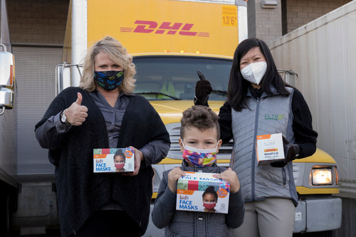 Mayor Dana Ralph of Kent, Washington (left) and Trang Le, a volunteer with both SmartAID and Restart Partners, celebrate the delivery of one million masks for children in Washington State by handing the first box of masks to a local boy. The one million masks are being donated by FLTR, Inc. to child care and youth programs throughout Washington State as part of the Millions of Masks for Children Initiative, a growing nationwide effort to help protect millions of children from COVID-19. FLTR, SmartAID, DHL, SEKO Logistics and other organizations are working together to deliver these masks.