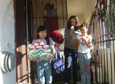 This little girl received gifts from USPS Operation Santa volunteers one Christmas Eve, with her sisters looking on. Smiles all around!