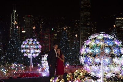 Los visitantes disfrutan de un "Show de luces y música navideña" con el increíble horizonte urbano como fondo en Harbour City en Hong Kong.