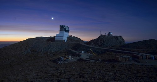 Rubin Observatory at sunset, lit by a full moon