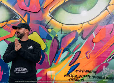 ABSTRK in front of his mural made in collaboration with Jack Daniel's® Tennessee Apple in Miami, FL.