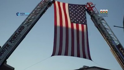 The American flag is hoisted by local fire companies during a Portland, Maine Wreaths Across America convoy stop.