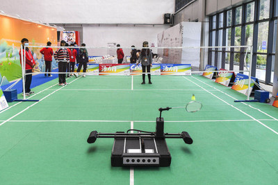 Visitors playing badminton with robots