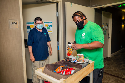 Chrysalis client and National Health Foundation staff member Paul serving snacks to guests at NHF's Project Roomkey site.