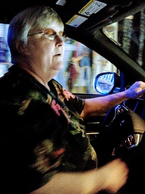 Terry Krech, who provides ride share users with sober, safe and comfortable rides, shown behind the wheel of her reliable Outlander PHEV.