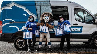 Comerica volunteers and Detroit Lions mascot, Roary, help deliver personal care kits to Detroit Public Schools Community District as part of the United Way Hometown Huddle.