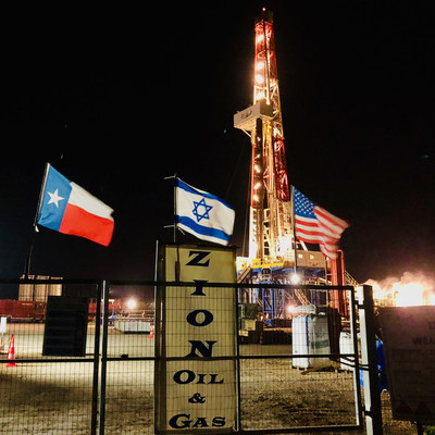 Flags of Texas, Israel, and the United States fly at night on January 26, 2021, in front of Zion’s drilling rig in Israel.