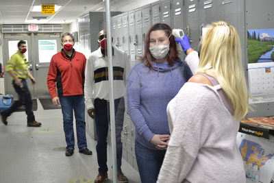 Sandridge employees line up for their daily temperature screening before starting their workday.