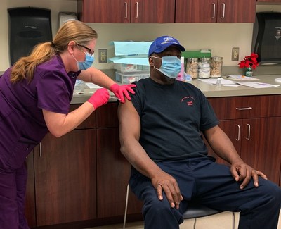 Melinda Tieskotter, supervisor of Perdue Farms' Accomac, Va. Wellness Center, administers the first round of the Moderna COVID-19 vaccine to live-haul associate James Edwards.