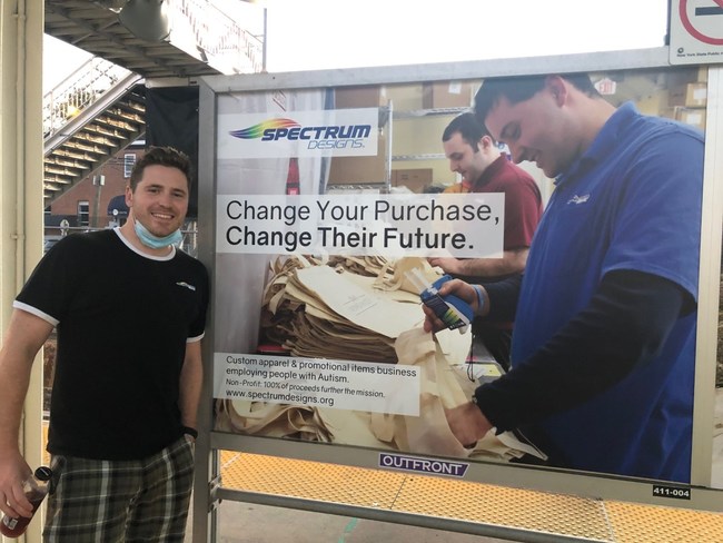 Co-Founder & CEO Patrick Bardsley poses with a Spectrum Designs ad on the LIRR platform