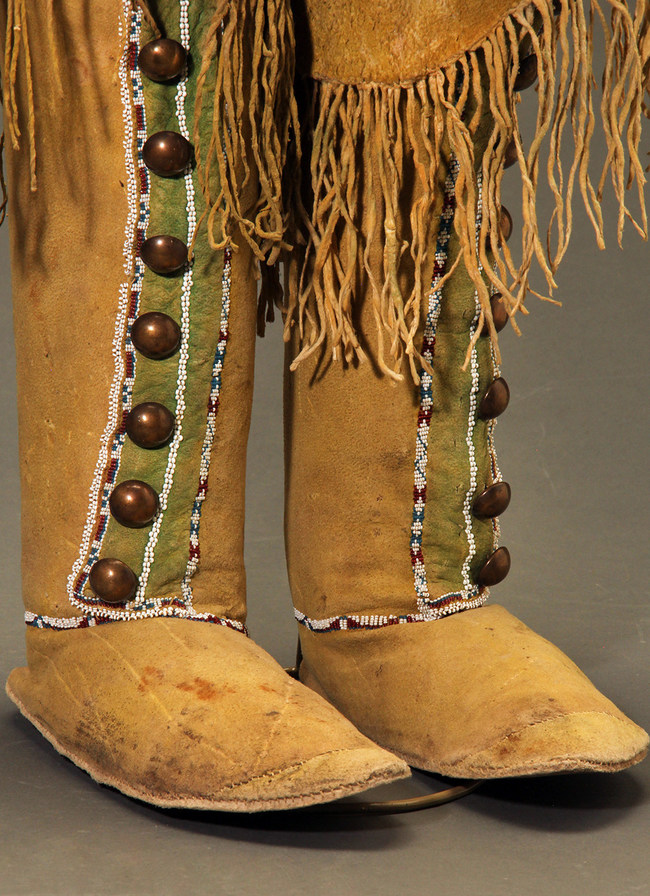 On offer from Sherwoods Spirit of America at the Virtual American Indian Art Show/ San Francisco. These Comanche high top hide moccasins feature hand rubbed yellow ochre and green mineral pigment, large domed trade brass buttons, rolled over top cuffs with long fringe, and buffalo hide soles. They date back to the 19th century and are 17 1/2 inches by 9 1/2 inches.