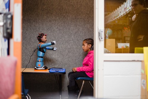 A student with Autism Spectrum Disorder is seen here working with Carver, one of four robot models developed by RoboKind.