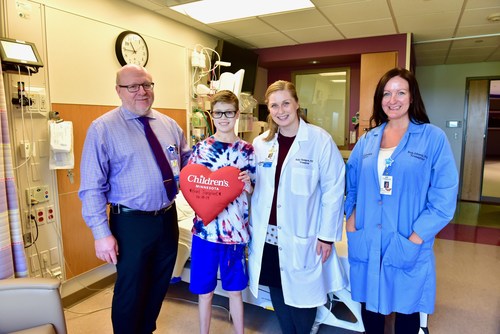 Children's Minnesota heart transplant patient with Dr. Erik Edens, medical director of the Heart Failure and Heart Transplant program, and other members of the transplant team.