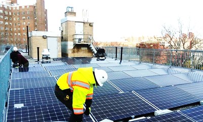 Workers installing solar panels at Carver Houses, a New York City Housing Authority development in northern Manhattan. Photo credit: Accord Power Inc.