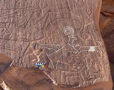 A team of archaeologists in north-west Saudi Arabia has uncovered the earliest evidence of dog domestication by the region's ancient inhabitants.
An AlUla rock art panel shows two dogs hunting an ibex, surrounded by cattle. The weathering patterns and superimpositions visible on this panel indicate a late Neolithic age for the engravings, within the date range of the burials at the recently excavated burial sites.