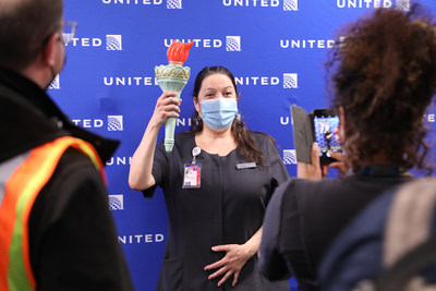 Esther Paz, United Customer Service agent poses with the torch carried cross country on the inaugural flight.