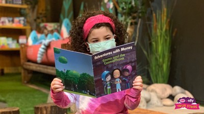 An elementary school student reads Ally's Adventures in Money book 