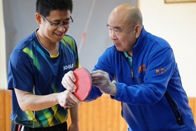 Liang Geliang trains an amateur player in Beijing on February 3 (PHOTO BY ZHANG WEI)