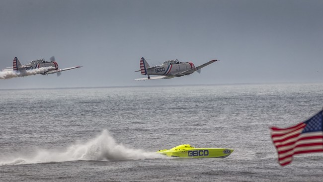 The solo pilots from the GEICO Skytypers Air Show Team compete in a sea vs sky duel against the 11 time world champion Miss GEICO catamaran.