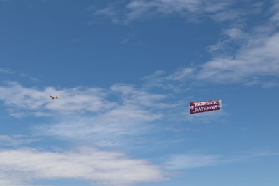 An airplane pulls a banners that reads, "Paid sick days now." (CNW Group/Unifor)