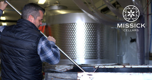 Winemaker Chris Missick, of Missick Cellars, conducting punch downs on a red wine fermentation.