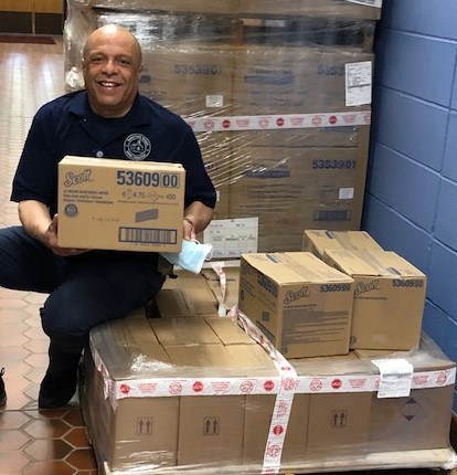 Carlos Rivera, the head custodian at Bethel Middle School in Connecticut, sits next to donated masks and cleaning products.