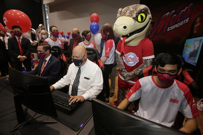 Florida Southern College’s mascot, Mocsie, watches as Drew Howard, director of athletics and dean of wellness, plays a round of Rocket League with Class of 1990 alumnus and CPS Investment Advisors President and CEO, Peter Golotko, and Mocs Esports player and sophomore Isaac Garay.